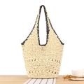 Schicke cremefarbene Stroh-Tote-Bag mit schwarzen Flechtgriffen auf einem Holztisch - Magnetverschluss / Beige