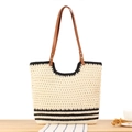 Borsa tote in tessuto crema con strisce nere e manici in pelle marrone sul tavolo - Righe Nere