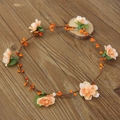 Diadema de corona de flores rosas y bayas naranjas sobre un fondo de madera - Naranja