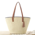 Cremefarbene Stroh-Tote-Bag mit braunen Ledergriffen und dekorativem Fransenanhänger - Beige
