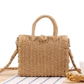 Beige gewebte Stroh-Box-Tasche mit Griff und Schultergurt in Urlaubsatmosphäre - Camel