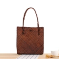 Borsa tote in paglia intrecciata a mano marrone scuro con manici su tavolo in legno - Colore Legno Antico