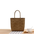 Handwoven gold tote bag with a unique wavy texture and round handles on a wooden table - Gold Brown Small