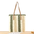 Bolso tote de paja a rayas verdes con asas de cuero marrón sobre superficie de madera - Verde
