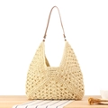 Borsa tote in paglia intrecciata beige con cinturini in pelle marrone su tavolo - Beige
