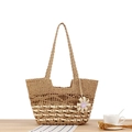 Handgewebte Boho-Stroh-Tasche in Naturtönen mit Blumenanhänger und langen Tragegriffen - Camel