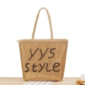 Hellbraune gewebte Stroh-Tote-Bag mit schwarzem YYS-Schriftzug auf Holzschreibtisch - Camel