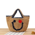 Natural straw woven tote bag with navy blue trim and fuzzy smiling face design - Blue Trim