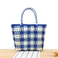 Blau-weiß karierte gewebte PVC-Tragetasche mit Spiralgriffen auf einer Holzoberfläche - Blau (Blumengewebe)
