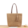 Beigefarbene Strohtasche mit braunen Ledergriffen und Quasten-Akzent für den Sommerurlaub - Camel