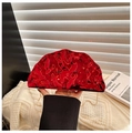 Detail of red ripple texture evening bag with golden ring handle and luxury metallic finish - Red