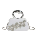 Macro shot of silver evening bag featuring crystal flower pattern and metal handle - White