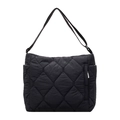 Detail of black quilted nylon tote showing smooth texture and adjustable shoulder strap - Black