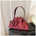 Detailed shot of burgundy suede bucket bag with drawstring and detachable mini pouch - Burgundy