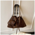 Close-up of brown matte drawstring bucket bag with detachable charm and shoulder strap - Brown