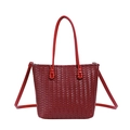 Detail view of deep red woven tote bag featuring leather texture and silver metal hardware - Red