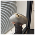 Silver pebble-shaped clutch bag with gold clasp and chain strap held by a model - Silver