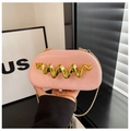 Detailed shot of pink leather clutch bag with wavy gold metal trim and chain strap - Pink