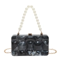 Detail of marble acrylic evening clutch with faux pearl handle and gold chain strap - Black