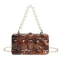 Detailed view of brown marbled acrylic evening clutch with pearl handle and gold chain - Brown