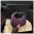 Detailed view of heart-shaped purple acrylic evening bag with gold chain and clasp - Purple