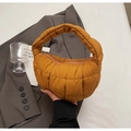 Macro shot of yellow quilted cloud handbag with detailed square pattern and zipper - Brown