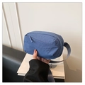 Detail shot of a blue nylon crossbody bag with textured fabric and durable zipper - Blue