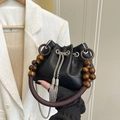 Black PU leather bucket bag with vintage wooden bead handle and metal tassels - Black