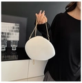 Minimalist white egg-shaped acrylic evening bag held by a model with a gold chain strap - White