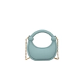 Macro detail of a light blue semi-circular acrylic bag with gold chain and matte finish - Light Blue
