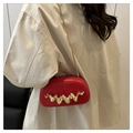 Close-up of a red acrylic evening bag featuring a gold wave handle and a fine chain strap - Red