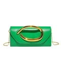 Macro shot of green leather clutch bag with signature gold ring handle and chain strap - Green