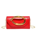 Detail of red leather envelope clutch featuring a large twisted gold metal handle - Red