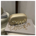Detail of champagne gold evening clutch with wavy metal accent and gold snake chain strap - Gold