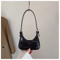 Détail d'un sac d'épaule en cuir verni noir brillant avec un grand nœud décoratif - Noir