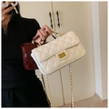 Close-up of quilted patent leather crossbody bags with gold turn-lock and chain straps - White