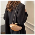 Rose gold metallic pebble clutch bag with gold chain strap worn over a black suit - Rose Gold