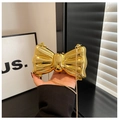 Detail of a mini golden bow-shaped hard shell clutch bag with a fine metal chain strap - Gold With Thin Metal Chain