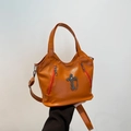 Chic orange faux leather crossbody bag with cross pendant and chain detail in motorcycle style - Brown