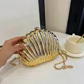 Golden shell-shaped evening clutch bag with metallic mirror finish and chain strap - Light gold