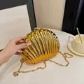 Glossy gold seashell clutch evening bag with elegant metal chain and spherical clasp - Gold