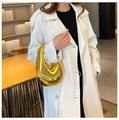 Schicke Acryl Abendtasche in Gold mit Metallkette getragen über einem weißen Mantel - Gold