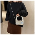 Dettaglio della pochette geometrica argento con catena su modella in ambiente moderno - Argento