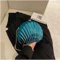 Dark teal shell-shaped evening clutch bag with gold chain strap held by a person - Blue