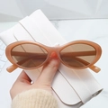 Dettaglio di occhiali da sole ovali rétro beige con custodia in pelle bianca martellata - Tè alla Gelatina
