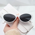 Detail of white cat-eye sunglasses with high-gloss finish on a white textured marble surface - Solid White Frame Grey Lens