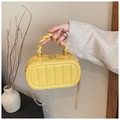 Détail du sac boîte jaune matelassé avec poignée torsadée et chaîne dorée - Jaune