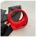 Makroaufnahme der roten Acryl-Halbmondtasche mit glänzendem Spiegeleffekt auf grauem Anzug - Großer Tragestil / Rot