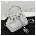 Detailed macro view of white sequin bucket bag with silver ring handle and tassel - White