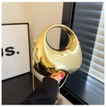 Dettaglio della borsa in acrilico dorato specchiato con design aerodinamico esclusivo - Oro